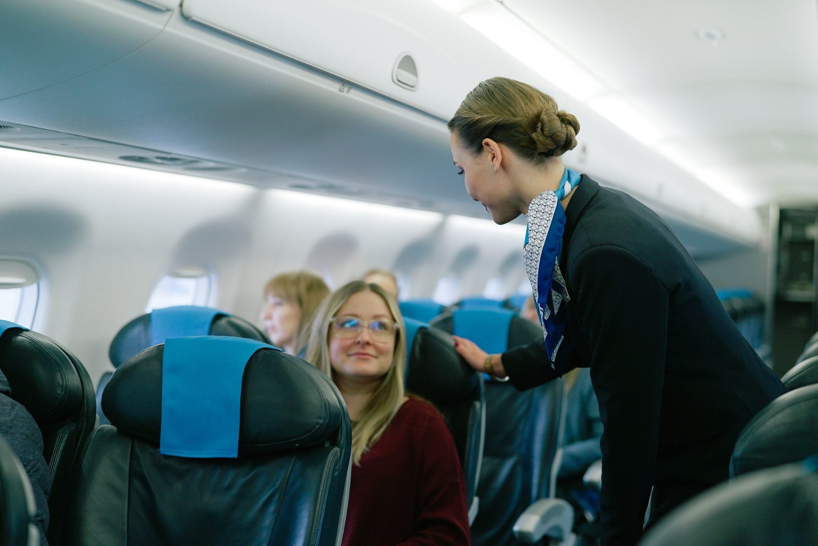 Cabin crew assisting passenger
